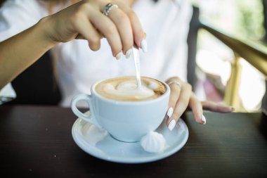 Genç kadın bir kahve karıştırma. Rahat kavramı
