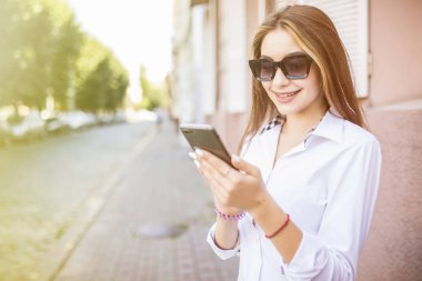 Çekici kadın cep telefonu temiz havada yürüyüş sırasında sohbet gülümseyen dışında yaz günü, yürüyüş sırasında cep telefonu kullanarak güzel bir kızın portresi
