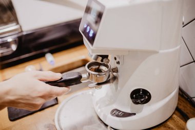 Seçilen odak profesyonel barista kahve pounder ahşap sapı ile kullanarak basarak ellerinde.