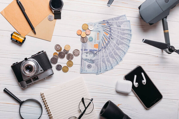 Set for travel on the background: money, camera, drone, phone and other accesories flat lay.