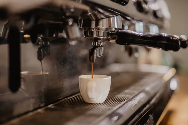 Coffee espresso. Espresso machine making coffee, golden espresso flowing.