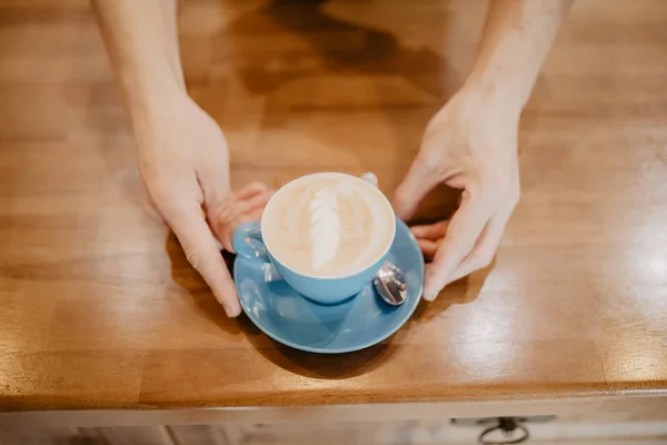 Ręka Trzyma Filiżanek Kawy Latte Drewnianym Stole Widok Góry Przerwa — Zdjęcie stockowe