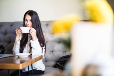 Genç kadın ahşap masa, kahve dükkanında oturmuş kahve içme