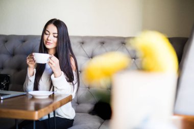 Genç kadın ahşap masa, kahve dükkanında oturmuş kahve içme