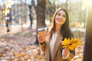 çekici bir kadın sonbahar ormanda kahve içme