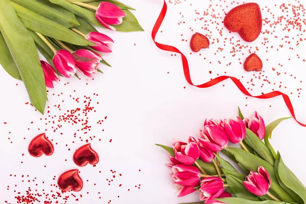 リボンやバレンタインデー、女性の日や母の日のグリーティング カードの白い背景に分離されたハートとピンクのチューリップ。春のコンセプト. — ストック写真