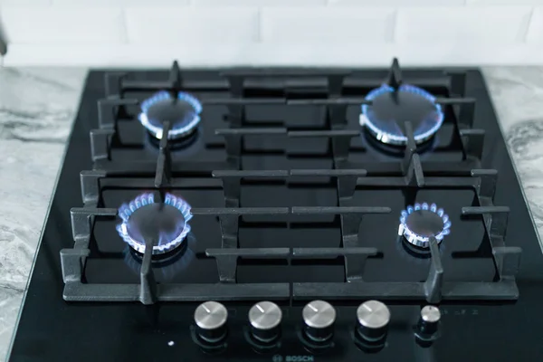 Cooktop with burning gas ring. Gas cooker with blue flames.