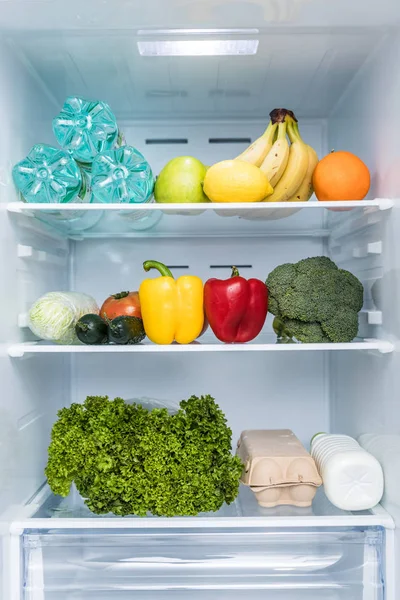 Open fridge full of fresh fruits and vegetables, healthy food background. Organic nutrition, health care, dieting concept