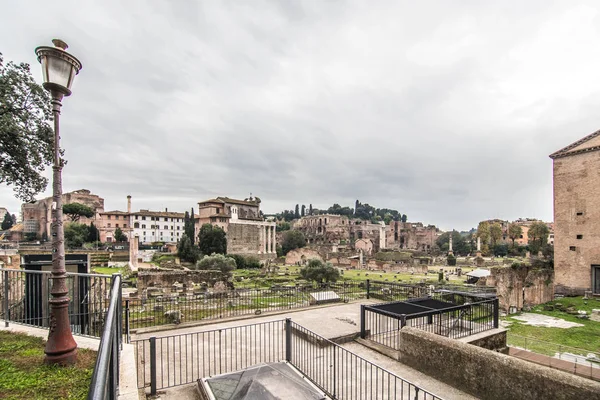 ROMA, ITALIA - Noviembre, 2018: Turistas en el Foro Romano en el Templo de Saturno contra el Arco de Septimio Severo. El centro histórico de Roma es Patrimonio de la Humanidad por la UNESCO — Foto de Stock