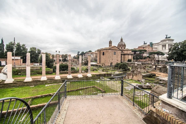ROMA, ITALIA - Noviembre, 2018: Turistas en el Foro Romano en el Templo de Saturno contra el Arco de Septimio Severo. El centro histórico de Roma es Patrimonio de la Humanidad por la UNESCO — Foto de Stock