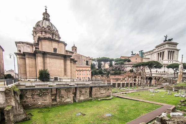 ROMA, ITALIA - Noviembre, 2018: Turistas en el Foro Romano en el Templo de Saturno contra el Arco de Septimio Severo. El centro histórico de Roma es Patrimonio de la Humanidad por la UNESCO — Foto de Stock