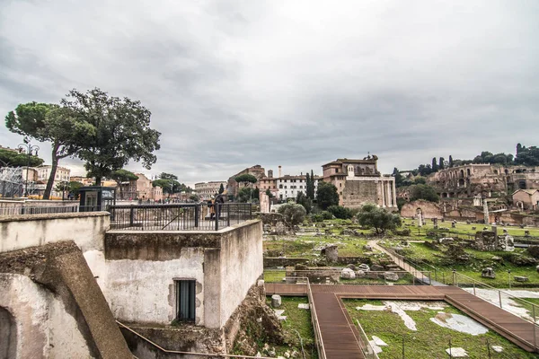 ROMA, ITALIA - Noviembre, 2018: Turistas en el Foro Romano en el Templo de Saturno contra el Arco de Septimio Severo. El centro histórico de Roma es Patrimonio de la Humanidad por la UNESCO — Foto de Stock