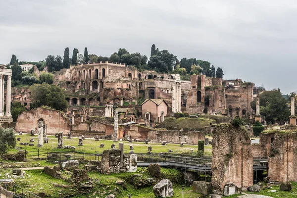 ROMA, ITALIA - Noviembre, 2018: Turistas en el Foro Romano en el Templo de Saturno contra el Arco de Septimio Severo. El centro histórico de Roma es Patrimonio de la Humanidad por la UNESCO — Foto de Stock