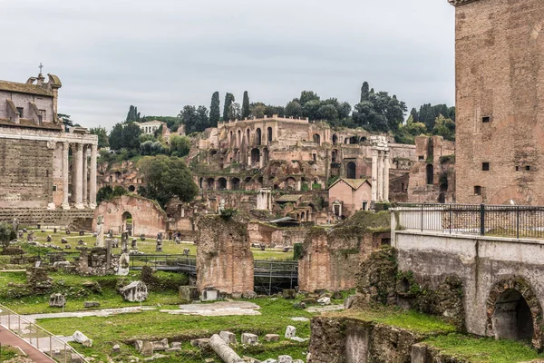 ROMA, ITALIA - Noviembre, 2018: Turistas en el Foro Romano en el Templo de Saturno contra el Arco de Septimio Severo. El centro histórico de Roma es Patrimonio de la Humanidad por la UNESCO — Foto de Stock