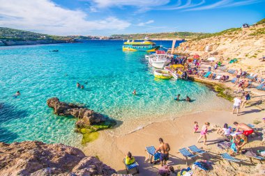Comino'daki, Malta - Kasım, 2018: açık turkuaz su ile güneşli yaz gününde zevk için Blue Lagoon turist kalabalığa açık mavi gökyüzü ve tekneler Comino Island, Malta.