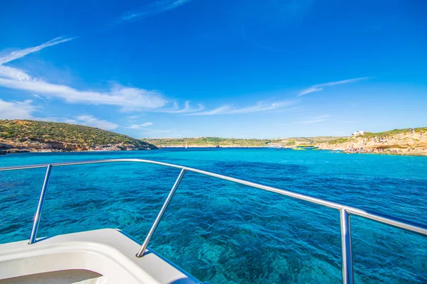 Comino, Malta - Noviembre, 2018: Turistas se congregan en Blue Lagoon para disfrutar del agua turquesa en un día soleado de verano con cielo azul claro y barcos en la isla de Comino, Malta . — Foto de Stock