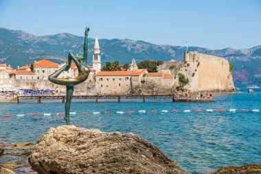 Budva, Karadağ - Temmuz 2019: Dansçı Kız Heykeli - Eski Budva kentinin arka planında turistler için çekici bir heykel ve popüler bir fotoğraf fırsatı.