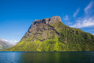 Urke köyü ve Hjorundfjorden fijord, Norveç 'in resimli bir manzarası. Dramatik gökyüzü ve kasvetli dağlar. Peyzaj fotoğrafçılığı