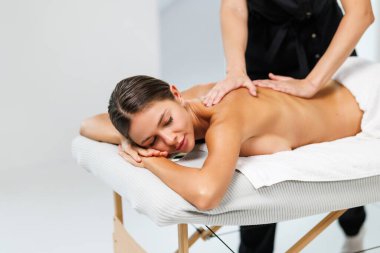 Kozmetik merkezindeki masörle sırt masajı yapan kadın. Rahatlatıcı bayan müşteri spa salonundaki masözle servis aromaterapi masajı yaptırıyor..