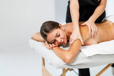 Kozmetik merkezindeki masörle sırt masajı yapan kadın. Rahatlatıcı bayan müşteri spa salonundaki masözle servis aromaterapi masajı yaptırıyor..