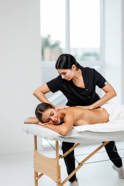 Genç bayan masajcı müşterisine masaj yapıyor.