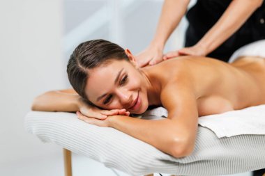 Spa terapisi. Salondaki masaj sırasında masada uzanan güzel genç bir kadın.