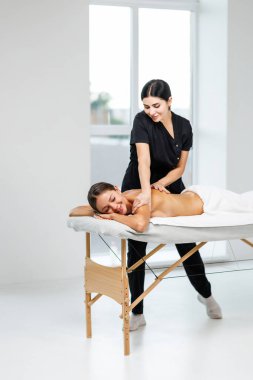 Spa terapisi. Güzeller güzeli genç bayan masaj sırasında masaya uzanıyor, yakın plan.