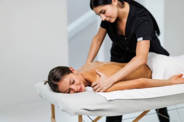 Spa terapisi. Güzeller güzeli genç bayan masaj sırasında masaya uzanıyor, yakın plan.