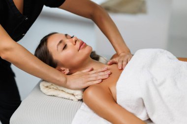 Kaplıcada yüz masajı yaparken kadın terapistin elleri rahat kadının çenesini ve boynunu ovuyor. Bin yıllık kadının iyileştirme akupunktur prosedürünü yüksek açılı görmesi