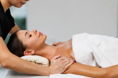 Kadın yüzüne masaj yapan masözlerin ellerini kapatın. Kadın zevkle gözlerini kapadı.