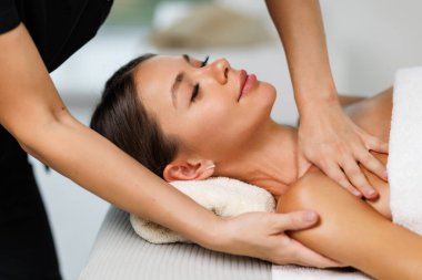 Kadın yüzüne masaj yapan masözlerin ellerini kapatın. Kadın zevkle gözlerini kapadı.