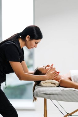 Eller, masaj ve kadın dinlenme tesisinde, hasta için yüz ve tedavi yatakta. Kuaförde havlu, spa ve lenf drenajı masöz, yüz veya stres giderici kozmetik terapi servisi tarafından yapılır.