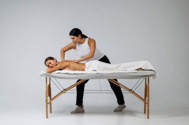 Pretty Woman kozmetik merkezindeki sırt masajından zevk alıyor, masaj koltuğunda yatıyor. Vücut bakımı, cilt bakımı, sağlık, refah, güzellik tedavi konsepti. ellere odaklan