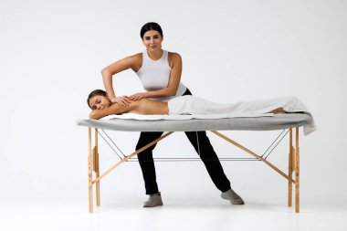 Genç bayan masajcı müşterisine masaj yapıyor.