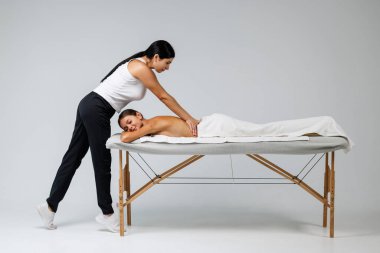 Çalışkan kadın masaj terapisti spa kompleksindeki rahatlatıcı kadına masaj yapıyor.