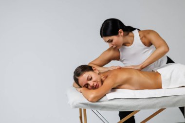 Çalışkan kadın masaj terapisti spa kompleksindeki rahatlatıcı kadına masaj yapıyor.