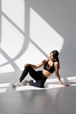 Gülümseyen genç kadın yoga indoo yapıyor.