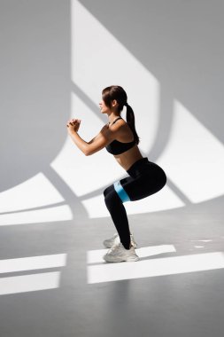 Beyaz arka plan üzerinde izole fitness döngü grubu ile ağız kavgası yapıyor ince sarışın kadın