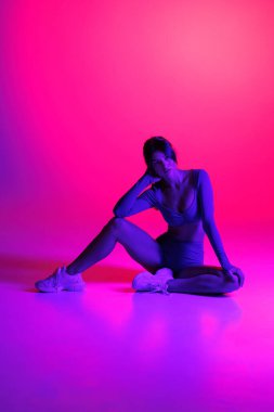 Baştan çıkarıcı, tapılası bir kadının fotoğrafı. Renkli desenli bir beden giyin. Dans pistinde dans edin.