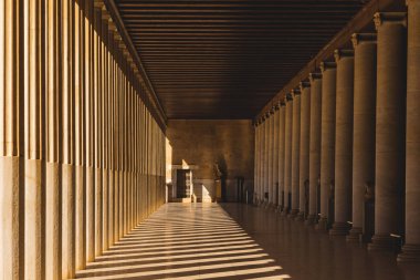 Atina, Yunanistan 'ın Antik Agora kentindeki Attalos Stoa' nın içinde güneş ışığı ve gölgelerle dolu bir koloni, yeniden inşa edilmiş bir simge ve ünlü bir klasik eser..