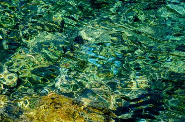 Turkuaz deniz suyunun soyut sanatsal dokusu ve Megara, Attica, Yunanistan 'daki Pachi limanında altın yansımaları seyahat, yaz, arka plan ve tasarım için uygundur..