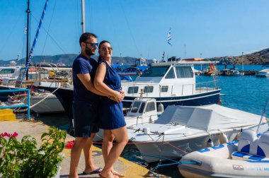 Yunanistan 'ın başkenti Megara' da Pachi limanında kucaklaşan çift, kıyıya demirlemiş tekne ve yatların yanında duruyor, aşk, romantizm ve yaz tatilini simgeliyor..