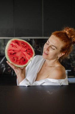 Elinde taze bir karpuz tutan gülümseyen kız, sulu meyveli yaz atmosferinin tadını çıkarıyor..