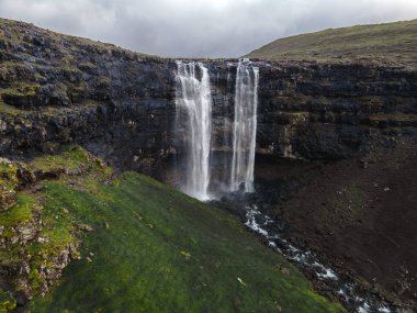 Muhteşem Fossa şelalesi, Faroe Adaları 'nın en yüksek şelalesi, Kuzey Atlantik' in engebeli kayalıklarından aşağı dökülüyor..