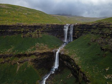 Muhteşem Fossa şelalesi, Faroe Adaları 'nın en yüksek şelalesi, Kuzey Atlantik' in engebeli kayalıklarından aşağı dökülüyor..