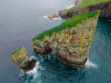 Danimarka 'nın Faroe Adası kıyı şeridi Faroe Adası, Avrupa' da sabahın erken saatlerinde yapılan yürüyüş sırasında Tindholmur adaları ile ünlü Drangarnir uçurumunun yakın plan çekimi. Yüksek kalite fotoğraf