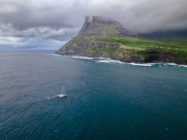 Dramatik Mulafossur şelalesi Gasadalur köyü ve arka planda kayalıklarla okyanusa dökülüyor..