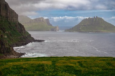 Dramatik Mulafossur şelalesi Gasadalur köyü ve arka planda kayalıklarla okyanusa dökülüyor..