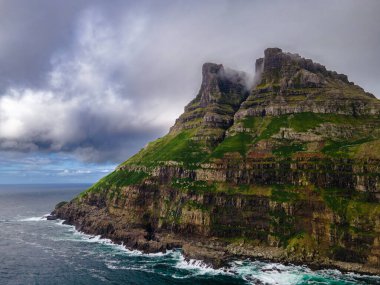 Dramatik Mulafossur şelalesi Gasadalur köyü ve arka planda kayalıklarla okyanusa dökülüyor..