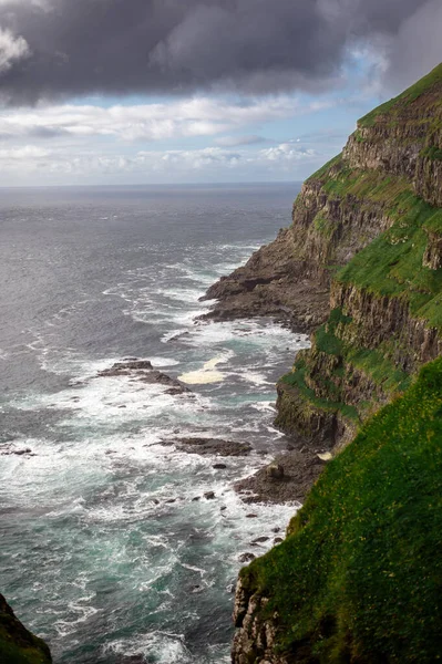Dramatik Mulafossur şelalesi Gasadalur köyü ve arka planda kayalıklarla okyanusa dökülüyor..